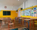 Pusta klasa z kolorowymi pracami dzieci na ścianie. Idealne miejsce, kiedy wolne od szkoły, by poczuć się jak uczeń.