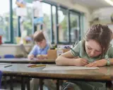Dziewczynka z piegami skupiona na rysowaniu, obok niej chłopiec. Czy to zadanie na średnią ocenę 4?
